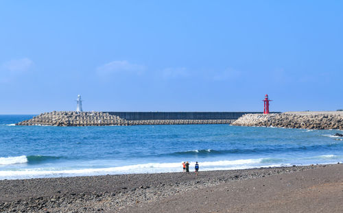 People on beach against sky