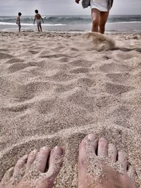 Low section of men on sandy beach