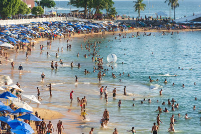 View of porto da barra full of people bathing in the sun and sea in the city of salvador, bahia.