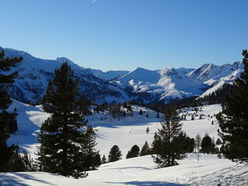 Scenic view of snowcapped mountains against clear blue sky