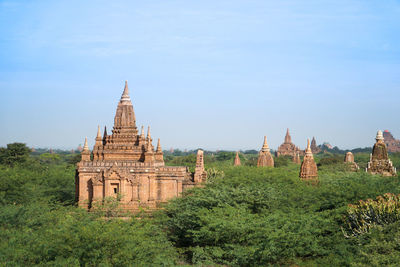 Panoramic view of pagodas in green fields in bagan