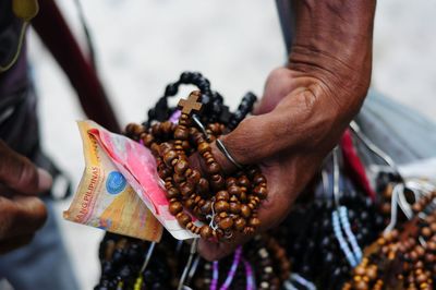 Close-up of vendor with money and rosaries