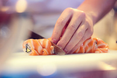 Cropped image of chef cutting sushi in restaurant