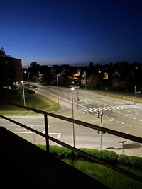 Illuminated street light against blue sky at night