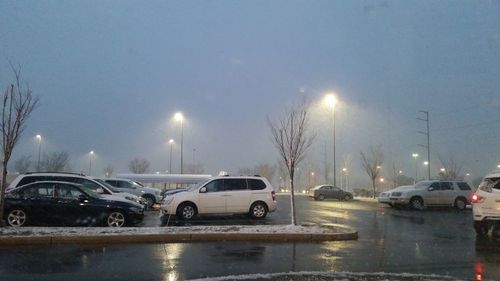 Cars on illuminated city street during winter