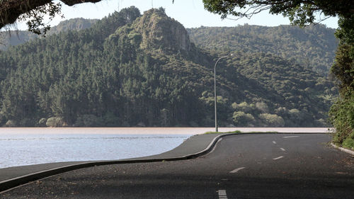 Street by lake against mountains