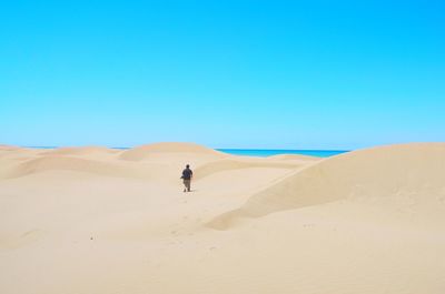 Scenic view of desert against clear blue sky