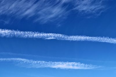 Low angle view of vapor trail against blue sky