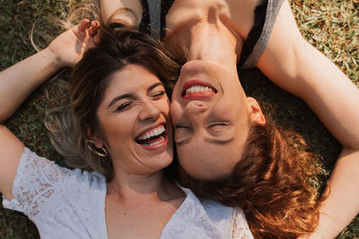 Portrait of smiling young people lying in the field