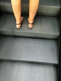 Low section of woman on escalator