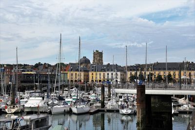 Sailboats moored at harbor