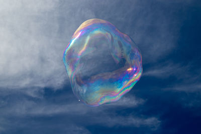 Low angle view of bubbles against rainbow in sky