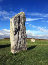 Stone wall on field against sky