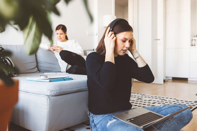 Side view of young woman using mobile phone in office