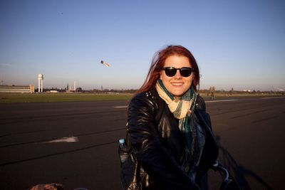 Portrait of smiling woman at tempelhof airport against clear blue sky