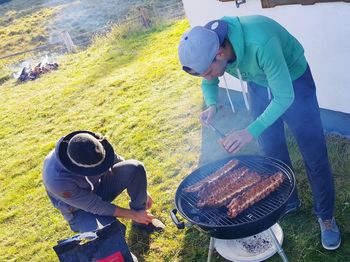 High angle view of man standing on barbecue grill