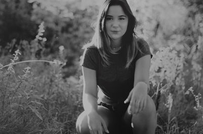 Portrait of young woman sitting on field