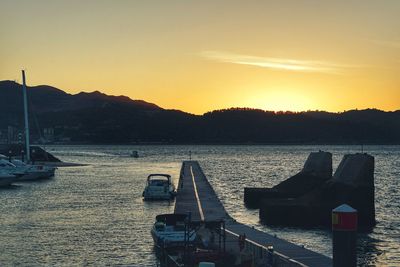 Boats sailing on sea against sky during sunset