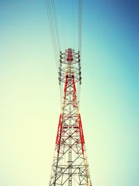 Low angle view of electricity pylon against clear blue sky