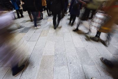 Low section of people walking on zebra crossing