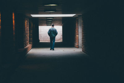 Rear view of man walking in corridor