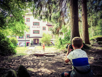 Rear view of boy standing by tree