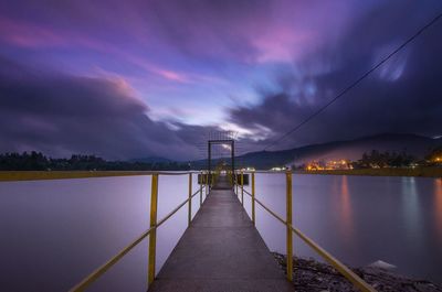 View of suspension bridge over river at sunset