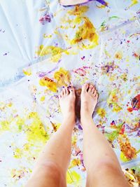 Low section of woman standing on messy textile