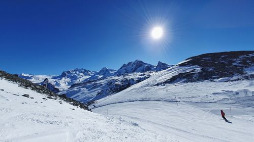 Scenic view of snowcapped mountains against clear blue sky