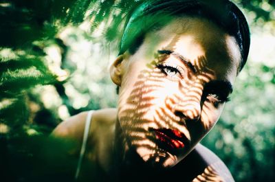 Close-up portrait of beautiful woman by plants