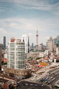 Buildings in city against cloudy sky