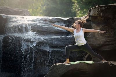Woman with arms raised on rock
