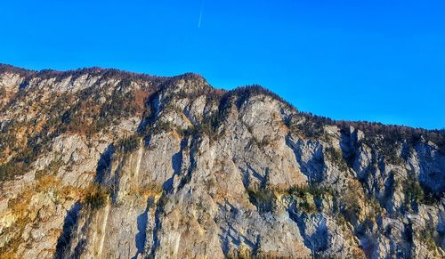 Low angle view of rock formation against clear blue sky