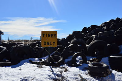 Low angle view of tire pile on snow covered field