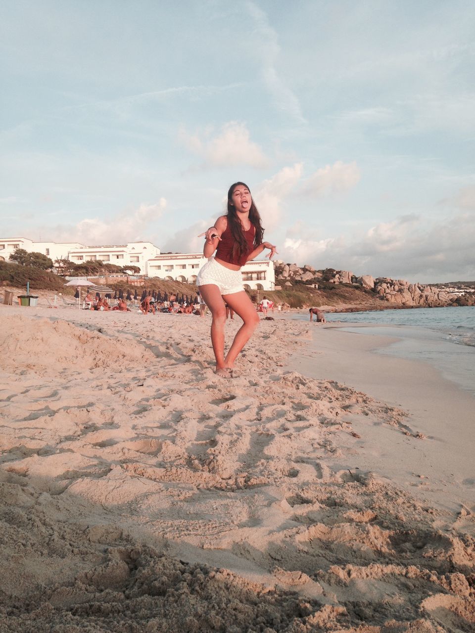 beach, lifestyles, sand, leisure activity, sea, shore, full length, sky, water, young adult, casual clothing, person, vacations, young women, enjoyment, sunglasses, weekend activities, standing