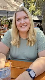 Portrait of smiling woman sitting on table