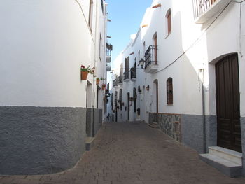 Walkway in city against clear sky