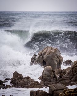 Scenic view of rocks on beach against sky