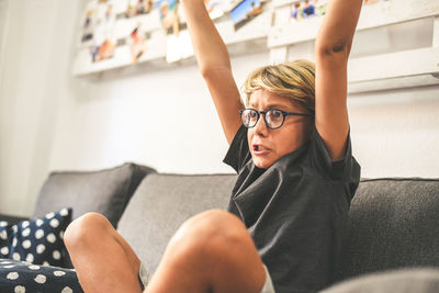 Boy sitting on sofa at home