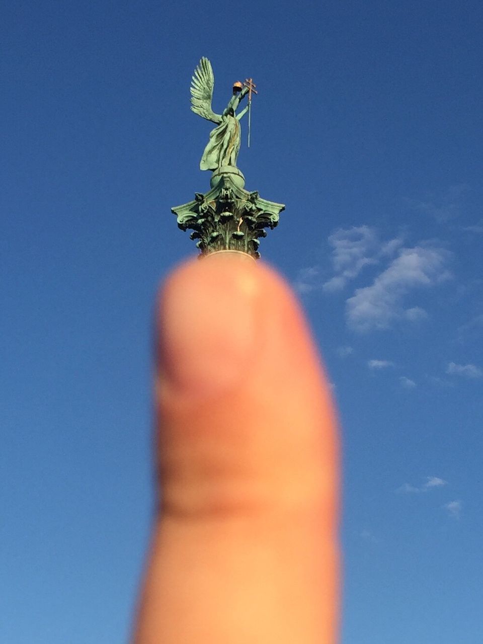 CLOSE-UP OF STATUE AGAINST BLUE SKY