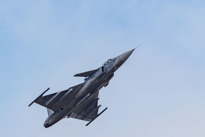 Low angle view of bird flying against blue sky