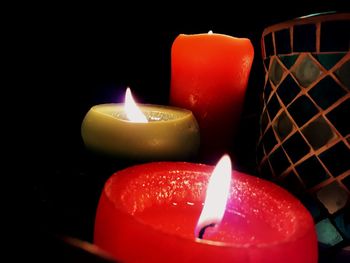 Close-up of illuminated candles in darkroom