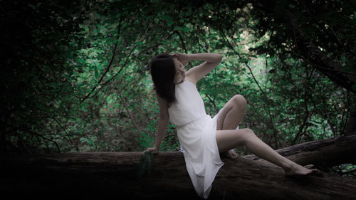 Side view of woman dancing in forest