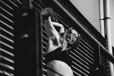 Low angle view of woman wearing lingerie while standing against wall