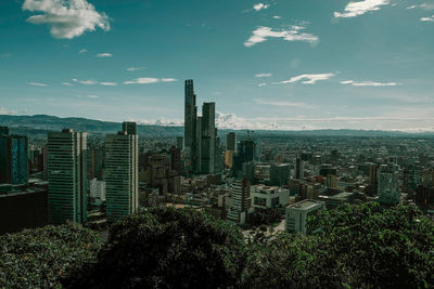 Aerial view of buildings in city against sky