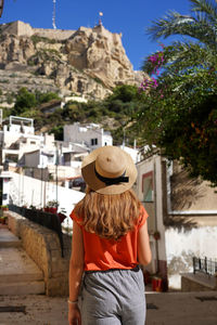 Girl in neighborhood santa cruz looking mount benacantil with santa barbara castle in alicante spain