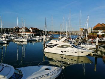 Boats moored at harbor against sky