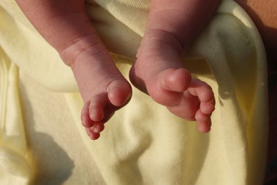 Low section of newborn lying on bed