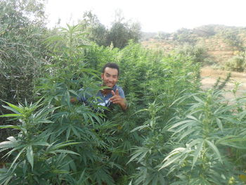 Portrait of man using mobile phone in field