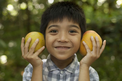 Portrait of happy boy holding apple